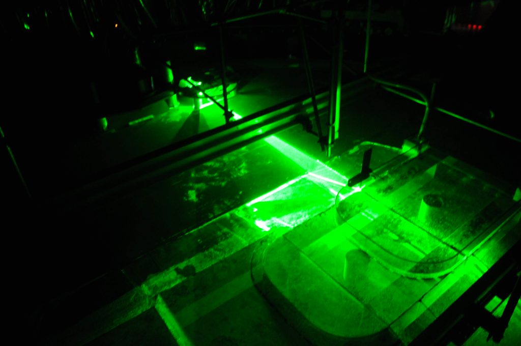 Green laser beams in the water, illuminating "Antarctica"
